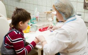врач берет у ребенка кровь